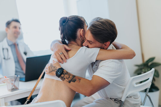 Couple hugging each other after their doctor or specialist informs on a positive pregnancy test.