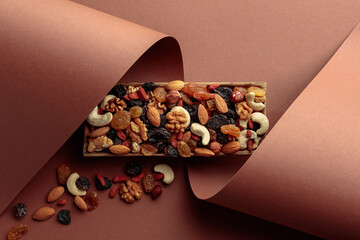 The mix of dried fruits and berries on a brown background.