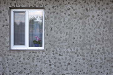Window and gray facade of the house. Texture of fresh putty design.