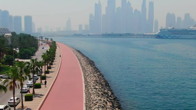 A drone flies over a road along the seashore near Dubai, United Arab Emirates
