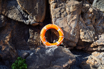 Vibrant Orange Lifebuoy on Rugged Lanzarote Coastline