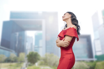 Elegant Asian Woman in Red Dress in Cityscape