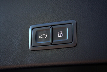 Close-up of the trunk release button. Сlose-up of the car black interior.