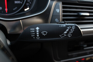 Close up on car rain windscreen wiper control stick. Modern car interior. - obrazy, fototapety, plakaty