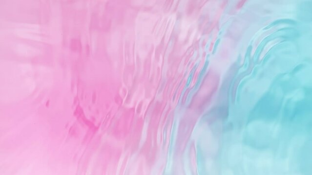 Super slow motion of splashing water surface on light blue pink background . Filmed on High Speed Cinematic Camera at 1000 FPS