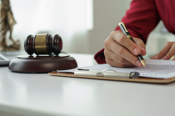 Attorney's office. Goddess of justice with scales and lawyer working on laptop Law, advice and justice concept Lawyer reads contract Young female lawyer or lawyer working in the office