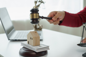 Attorney's office. Goddess of justice with scales and lawyer working on laptop Law, advice and justice concept Lawyer reads contract Young female lawyer or lawyer working in the office