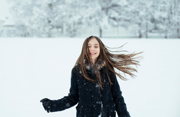 Little cute girl having a fun with a snow in winter cold weather.  Winter season joying.