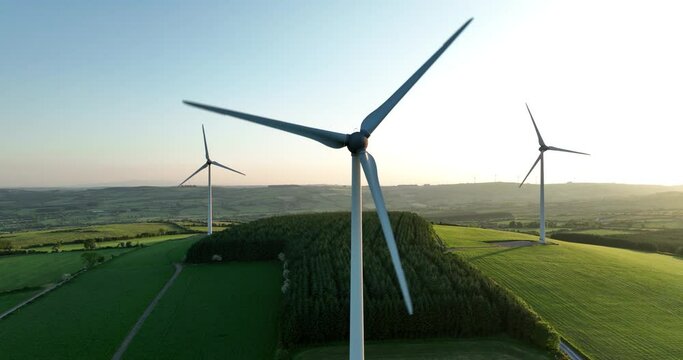 Three windmills stand at sunset 4k