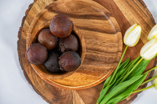 Unniyappam or Unni appam - Traditional kerala deep fried snack with rice dry coconut jaggery ghee , selective focused image. Unniyappam in a wooden bowl and isolated background ..