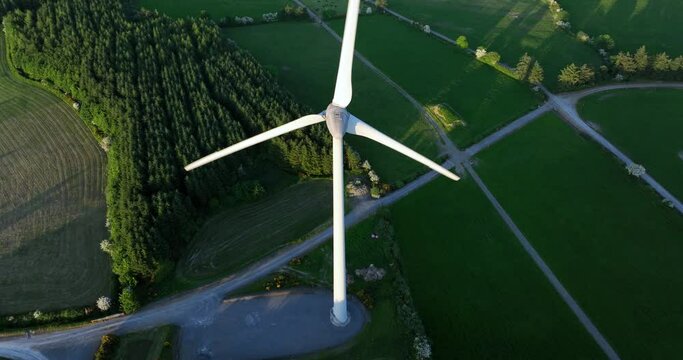 Large wind turbine with blades on green field aerial view of green valley 5k