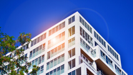 Exterior of a high modern multi-story apartment building - facade, windows and balconies. - obrazy, fototapety, plakaty