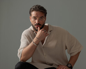bearded young man with glasses sensually touching lips