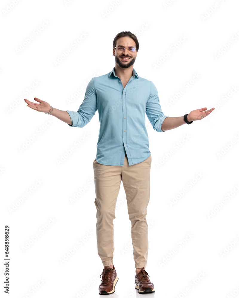 Wall mural proud young man with glasses opening arms and inviting while smiling