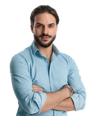 Obraz premium proud young man with beard folding arms and looking forward