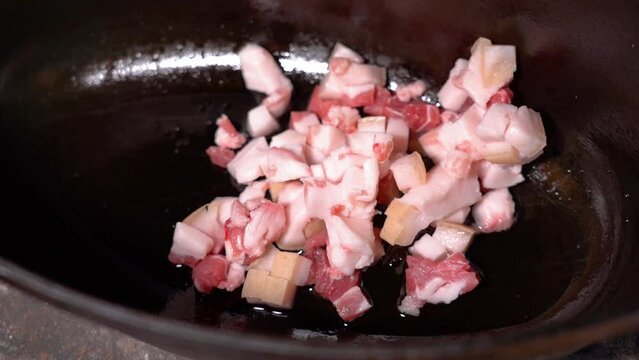 roasting of salted pork fatback on a red-hot pan, close-up	
