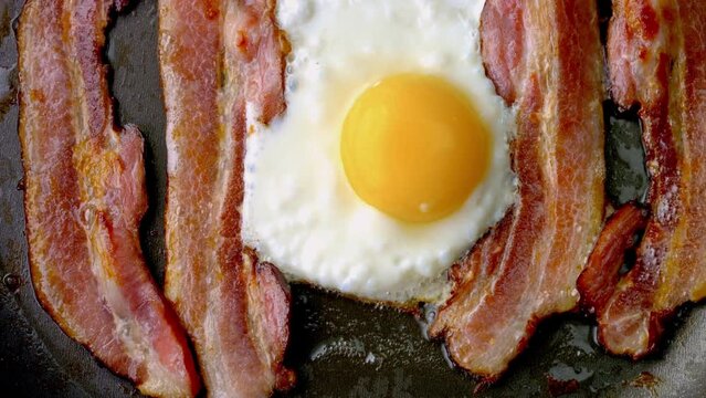 Sizzle and Sunshine: Close-Up of Cooking Bacon and Egg in a Pan in 4K Video