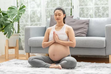 Fototapeten Happy Calm Pregnant Woman deep breath with fresh air do yoga lotus pose comfortable at home,Pregnancy of young woman relax with yoga to meditation for healthy life,Yoga Motherhood and Pregnant Concept © 220 Selfmade studio