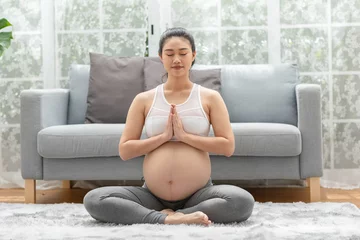 Fototapeten Happy Calm Pregnant Woman deep breath with fresh air do yoga lotus pose comfortable at home,Pregnancy of young woman relax with yoga to meditation for healthy life,Yoga Motherhood and Pregnant Concept © 220 Selfmade studio