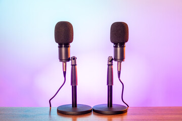 Two microphones for podcasting on a colorful background