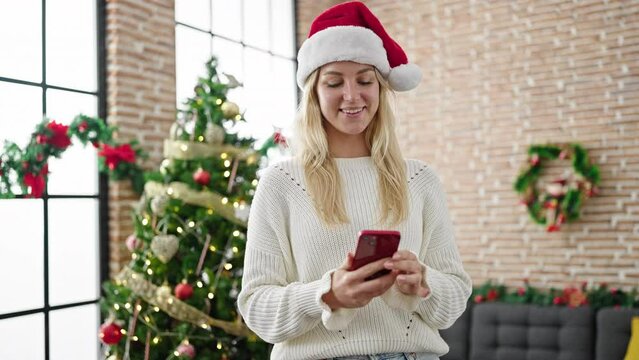 Young blonde woman taking a selfie picture celebrating christmas at home