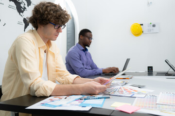 Multiethnic team of architects and designers are meeting to brainstorm design an application...