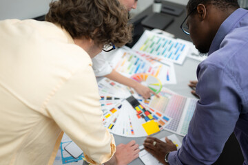 Multiethnic team of architects and designers are meeting to brainstorm design an application...