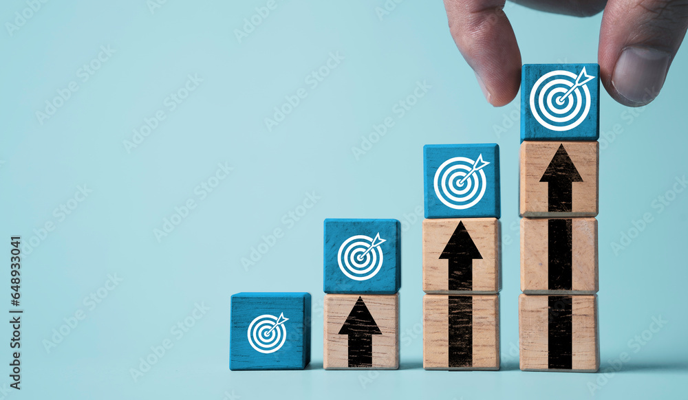 Poster hand stacking dartboard on the top of up arrow for enhance setup business objective target and goal 