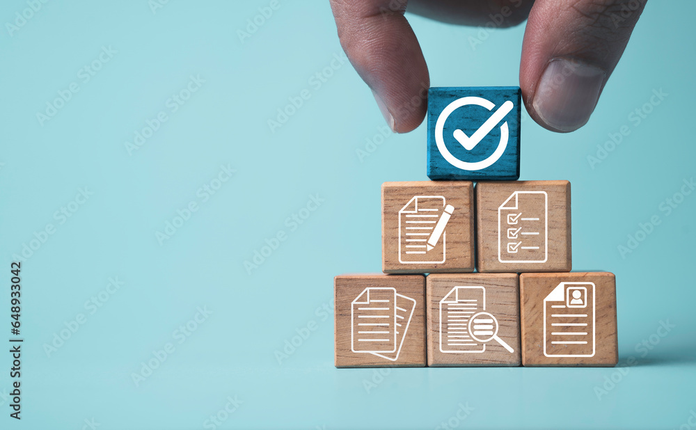 Poster hand holding white correct sign mark on blue wooden block cube and the top of document icon for iso 