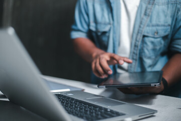 A business man is checking daily online stock market prices through a laptop at home with graphs displayed on the screen. Concept of daily business uncle