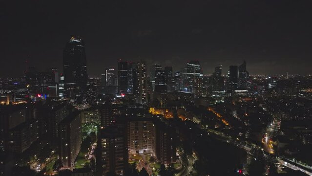 Paris' nocturnal pulse: Financial towers gleaming beside the Seine's shimmering path.

