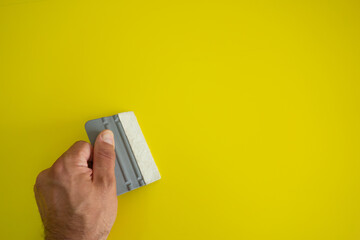 Hand with a plastic squeegee to glue the vinyl film to the surface. Pasting of interior details...