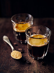 Two glasses of intense espresso coffee on rustic wooden background. Close-up. Copy space - 648953275