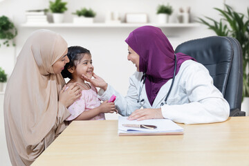 Muslim doctor wear hijab check child at clinic. female pediatrician examine kid patient with her mother. Health care and medical,  Ethnicity. 