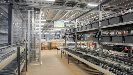 Fototapeta premium Сonveyor belt in sorting area and racks with boxes