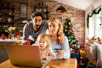 Young caucasian family shopping online for presents for christmas and the new year holidays