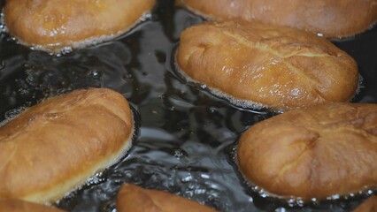 Deep fry the pies in oil. Meat pies are deep-fried, pies in vegetable oil close-up, pies in fixing oil, Pie dough fry.