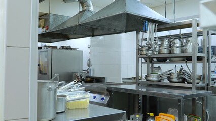 Restaurant kitchen without people, kitchen utensils, pots, trays and pans.