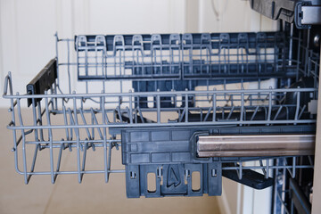 Unloading of washed dishes from the dishwasher. Empty dishwasher tray