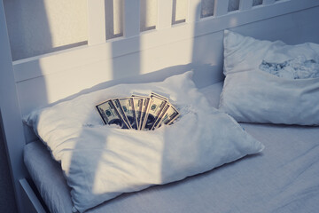 The money is hidden in a stash in a secret pillow A torn pillow with US dollars