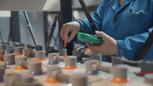 Closeup of woman hands checking voltage with multimeter tester