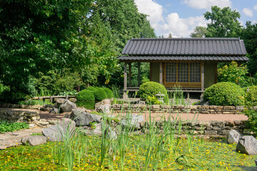 Fototapeta na wymiar tea house near pond in japanese garden