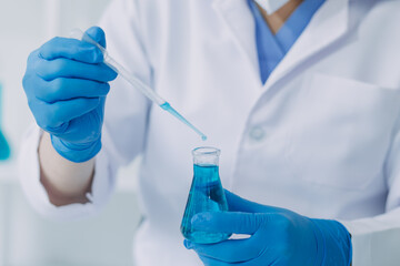 Fototapeta premium Young scientists conducting research investigations in a medical laboratory, a researcher in the foreground is using a microscope