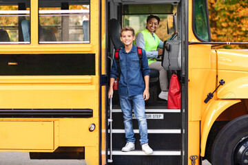 Smiling preteen boy getting of the yellow school bus
