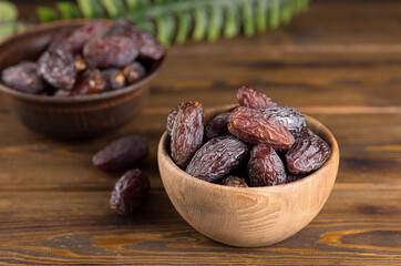 In a wooden bowl on the table are dates