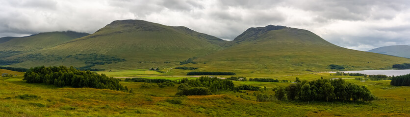Great panorama of the mountainous and green landscape with lakes of the Glencoe Valley, Scotland