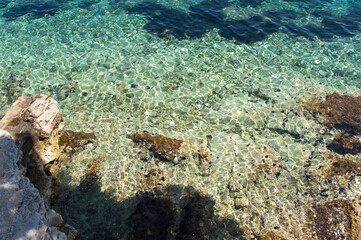 Naklejka na ściany i meble Transparent and crystal clear sea water of Adriatic sea, rocky beach in Korcula, Croatia