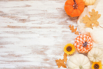 Autumn country farmhouse side border over a white wood background. Orange and white cloth pumpkins,...