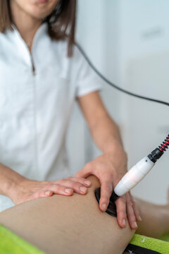 Anonymous therapist doing shock wave therapy to patient