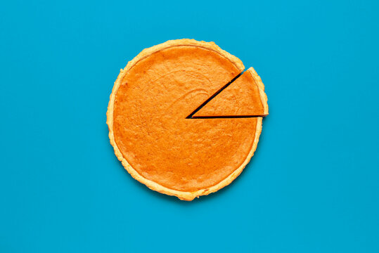 Homemade pumpkin pie isolated on a blue background